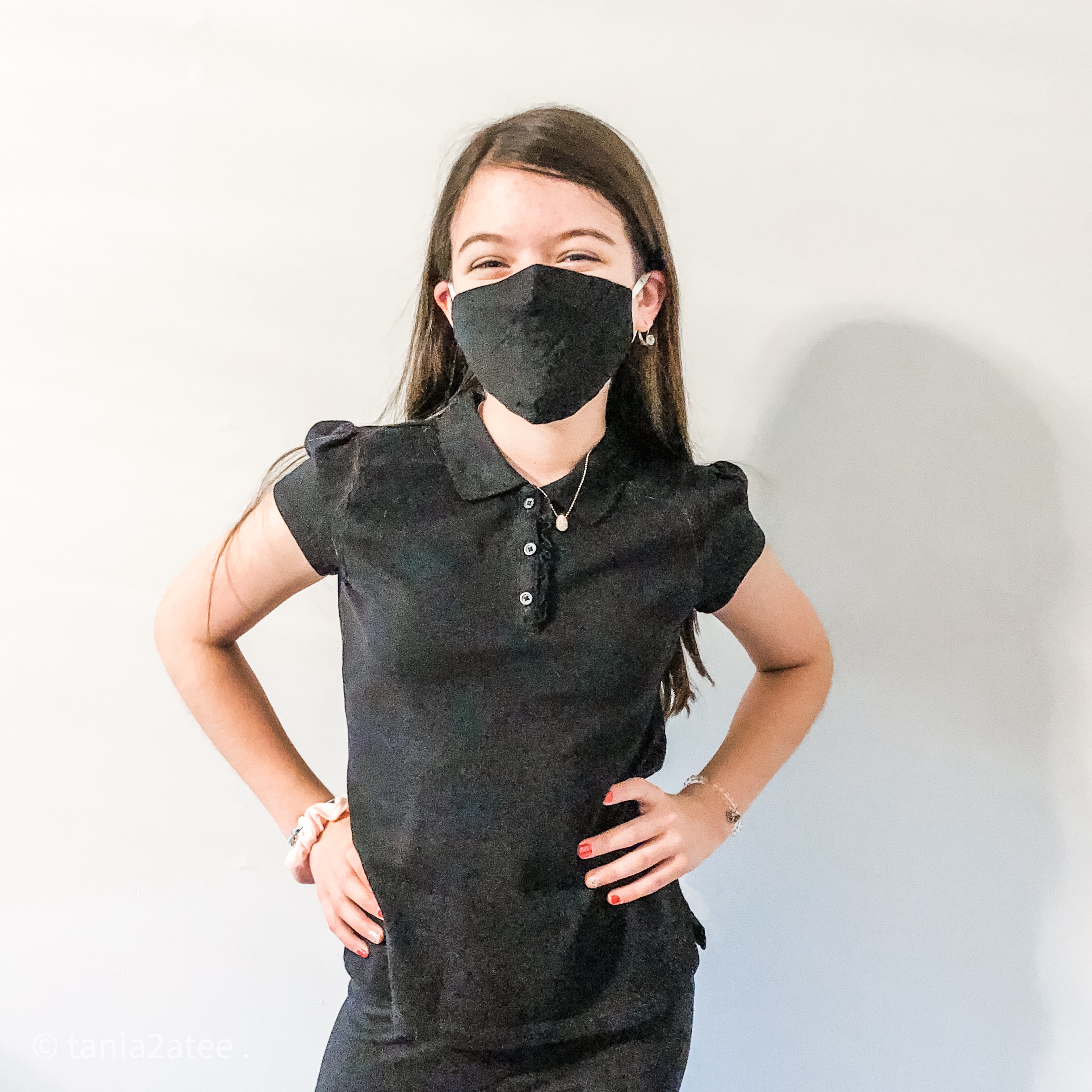 girl posing for camera wearing black top and pants and black face mask