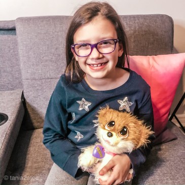 little girls with glasses holding stuffed puppy