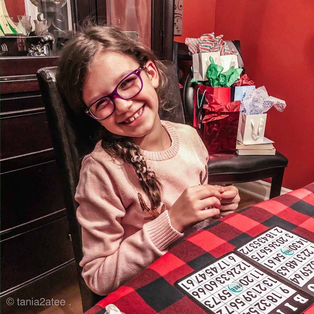little girl wearing glassing playing bingo