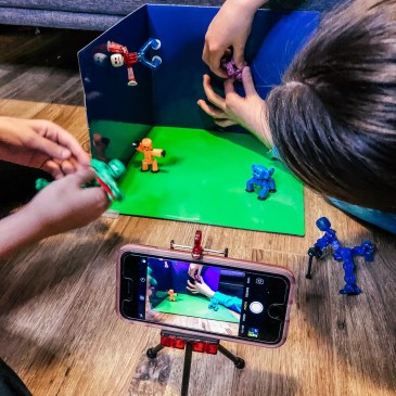 girls setting up toys on green screen for stop-motion video