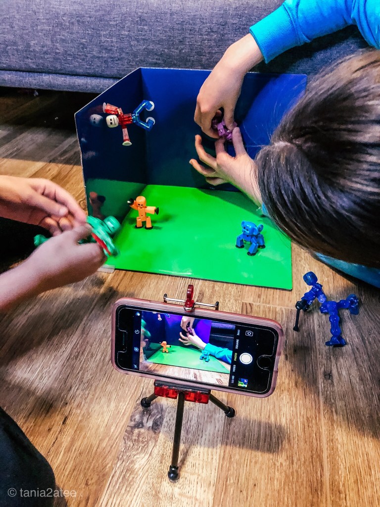 girls setting up toys on green screen for stop-motion video