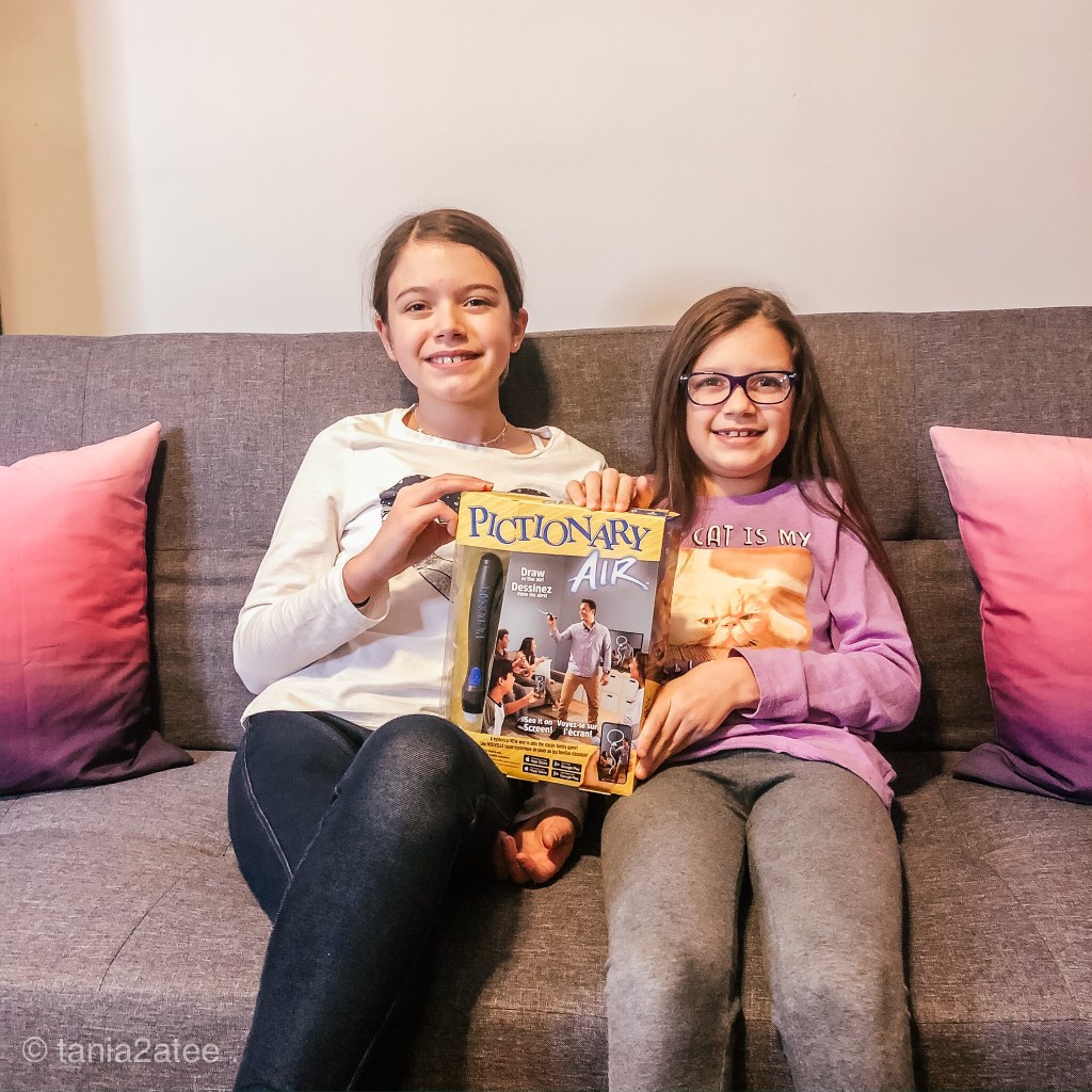 two girls holding Pictionary Air game