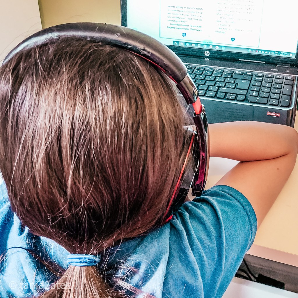 girls in front of laptop wearing headphones