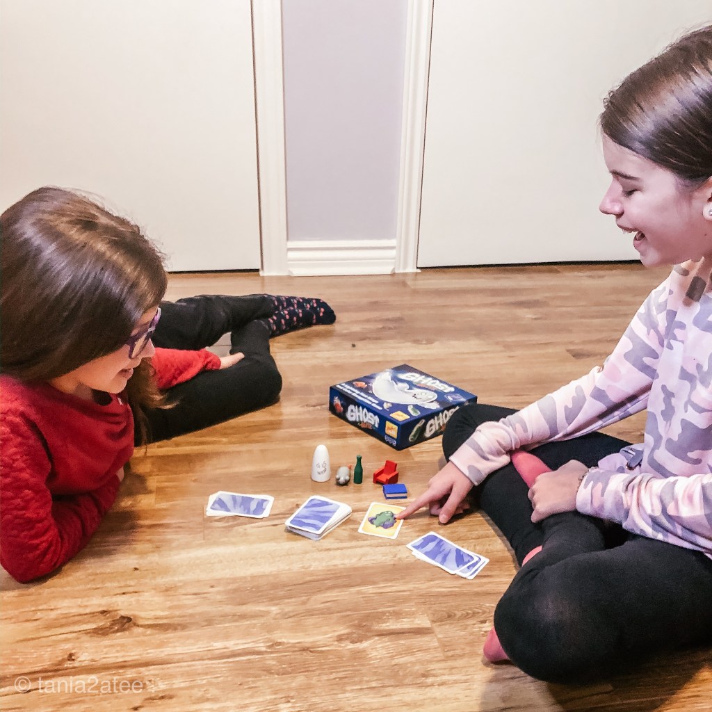 girls playing board game looking at cards