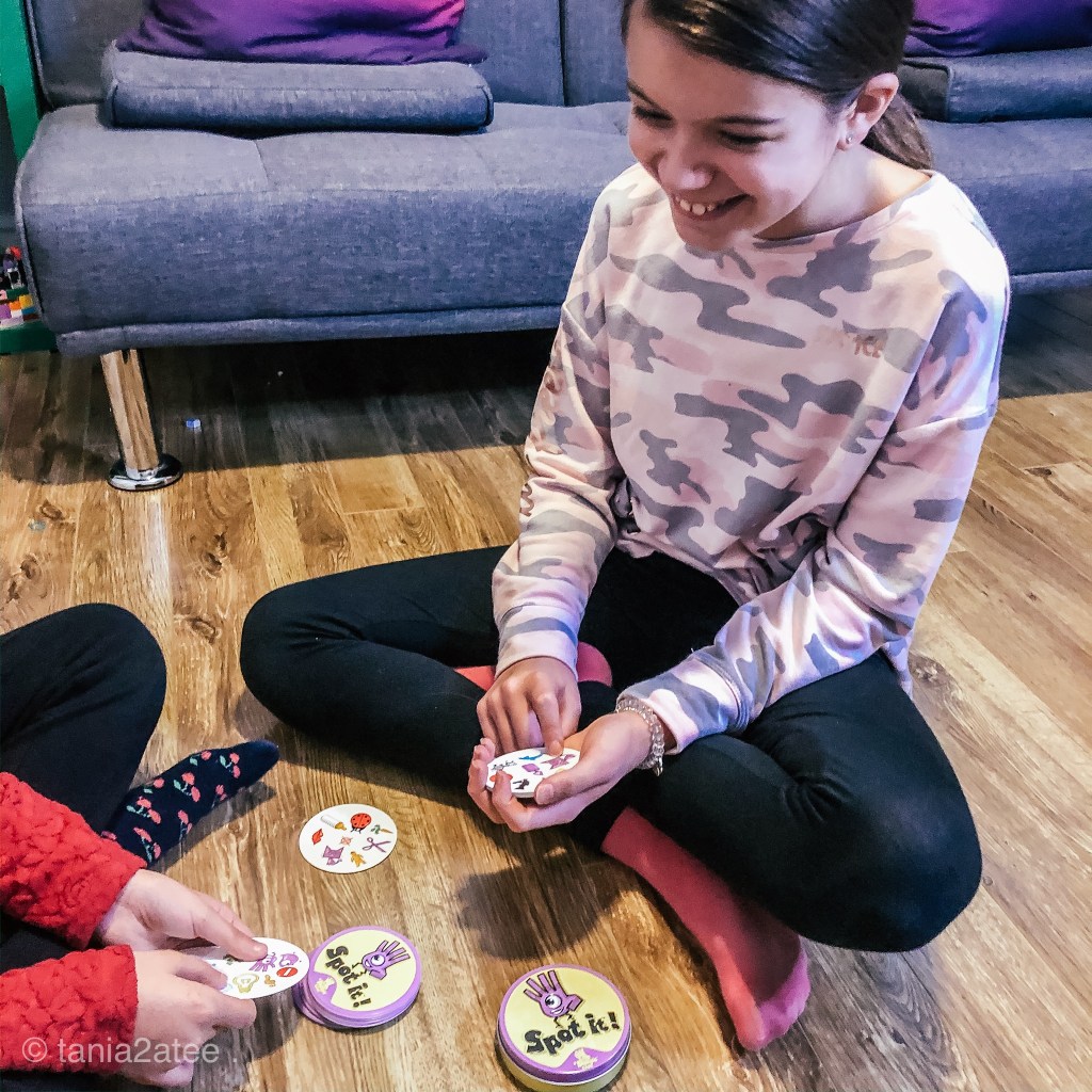two girls playing game of cards and smiling